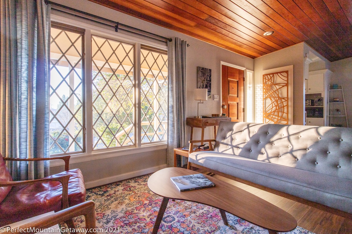 Couch and coffee table in a living room with large windows.