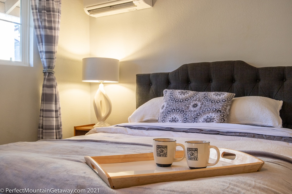 Bedroom with a tray of two coffee mugs on the bed.