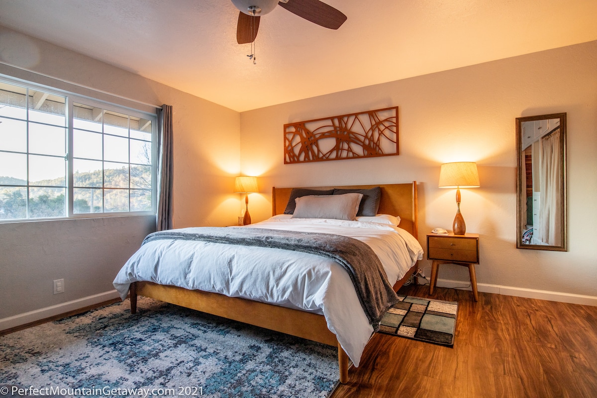 Bedroom with a large bed, nightstands, lamps, and a window.