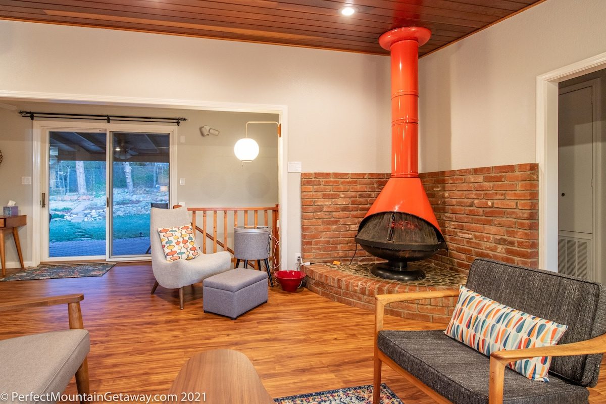 Wood-burning stove in living room with hardwood floors.