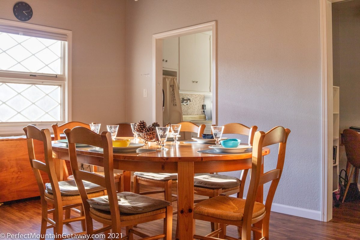 Wooden dining table set for meal in a room with natural light.